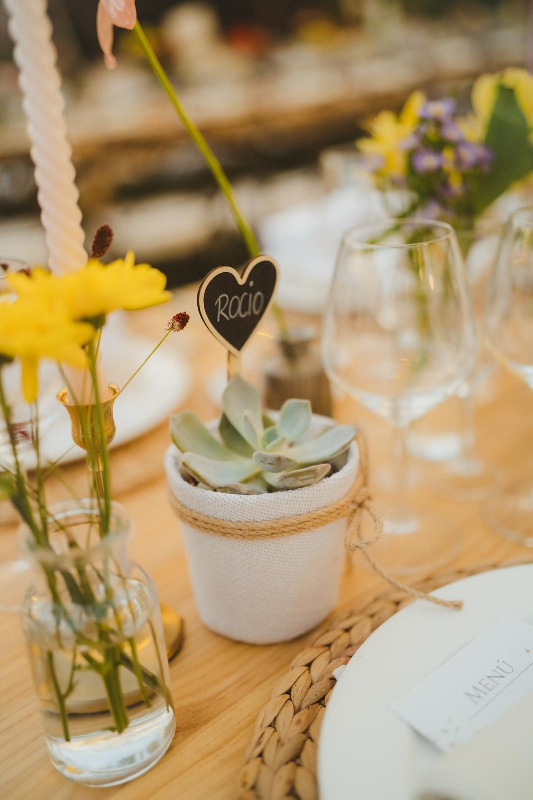 Detalle de mesa con suculenta, flores amarillas y marcador de nombre
